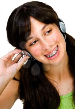 Close-up of a teenage girl wearing headphones and listening to music isolated over white