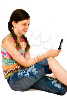 Happy girl text messaging on a mobile phone isolated over white