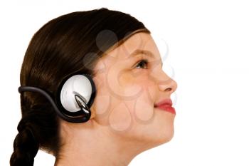 Cute girl listening to music on headphones isolated over white