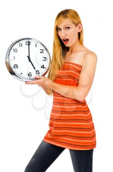 Shocked young woman holding a clock isolated over white