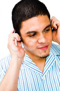 Young man listening to headphones isolated over white