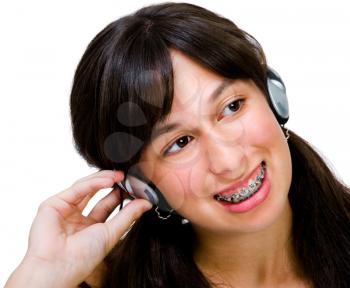 Teenage girl wearing headphones and listening to music isolated over white