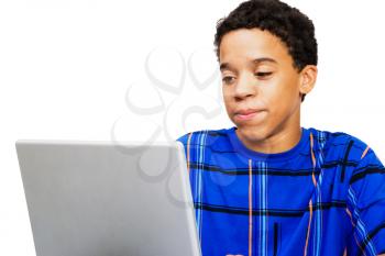 Teenage boy looking at a laptop isolated over white