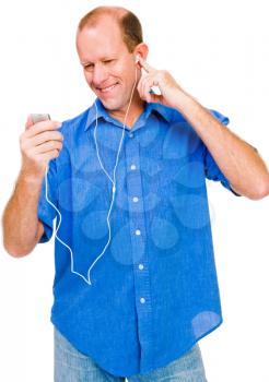 Confident man listening to MP3 player and smiling isolated over white