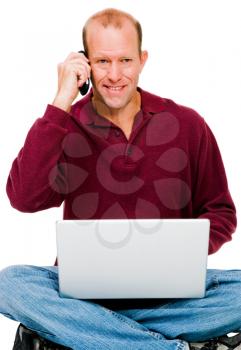 Portrait of a man using a laptop and a mobile isolated over white
