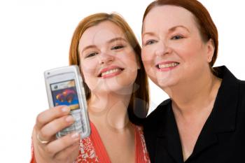 Happy women photographing themself with a mobile phone isolated over white