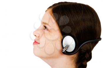 Caucasian girl listening to music on headphones isolated over white
