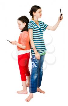 Smiling girls text messaging on mobile phones isolated over white