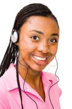 Portrait of a teenage girl listening to music on headphones isolated over white