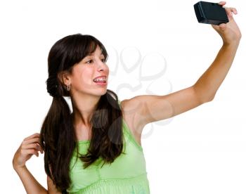 Confident teenage girl photographing herself with a camera isolated over white