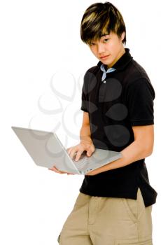Teenage boy using a laptop and posing isolated over white