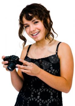 Teenage girl photographing with a camera and smiling isolated over white
