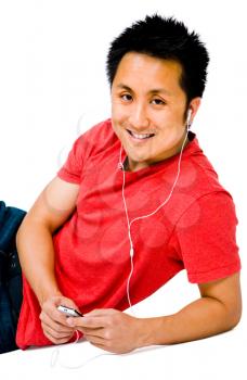 Asian man listening to music on a MP3 player isolated over white