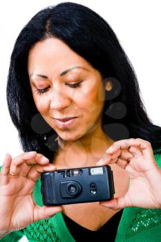 Close-up of a mid adult woman photographing with a camera isolated over white