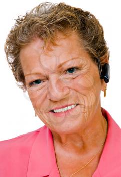 Confident woman wearing a bluetooth and smiling isolated over white
