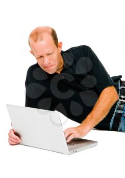 Happy man lying and using a laptop isolated over white