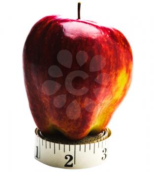 Red apple on a roll of measuring tape isolated over white