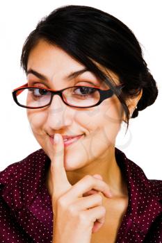 Close-up of a woman posing with her finger on her mouth isolated over white