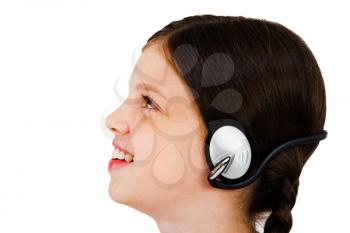 Beautiful girl listening to music on headphones isolated over white