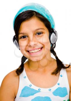 Pre adolescent girl listening to music on a headphones isolated over white