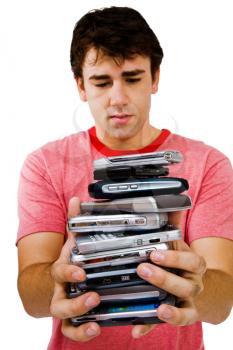 Close-up of a man holding a stack of mobile phones isolated over white