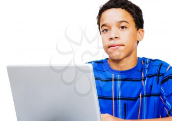 Teenage boy working on a laptop isolated over white