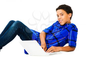 Teenage boy reclining and using a laptop isolated over white
