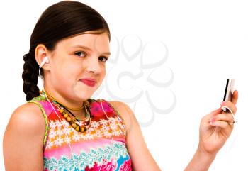Smiling girl listening to music on MP3 player isolated over white