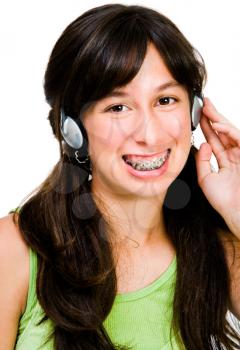 Teenage girl wearing headphones and listening to music isolated over white