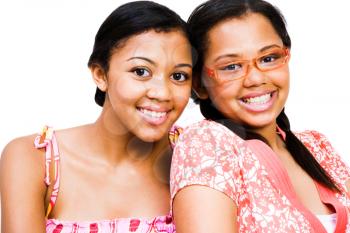 Portrait of two teenage girls smiling isolated over white