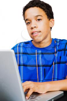 Teenage boy using a laptop isolated over white