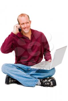 Happy man using a laptop and a mobile isolated over white