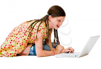 Confident girl using a laptop and smiling isolated over white