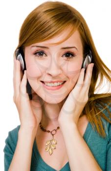Mixedrace woman wearing headphones and listening to music isolated over white