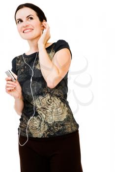 Young woman listening to music on MP3 player isolated over white
