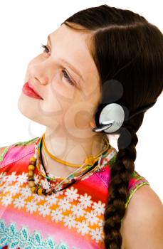 Girl listening to music on headphones and smiling isolated over white