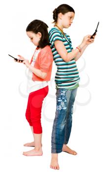 Girls text messaging on mobile phones isolated over white