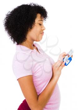 Happy teenage girl text messaging on a mobile phone isolated over white