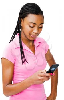 Teenager text messaging on a mobile phone and smiling isolated over white