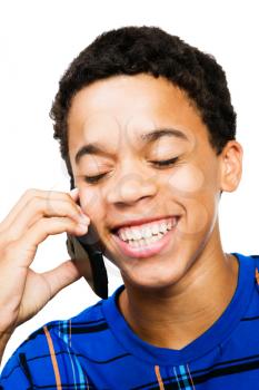 Smiling teenage boy using a phone isolated over white