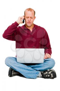 Caucasian man using a laptop and a mobile isolated over white