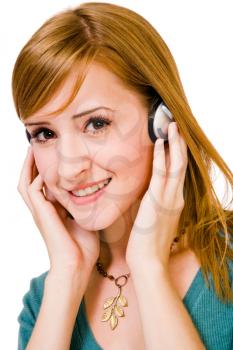 Confident woman wearing headphones and listening to music isolated over white