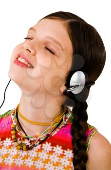 Child listening to music on headphones and smiling isolated over white