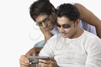Two friends text messaging on a mobile phone