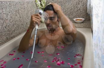 Man taking a shower in a bathtub