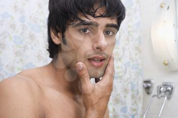 Portrait of a man touching his face after shave