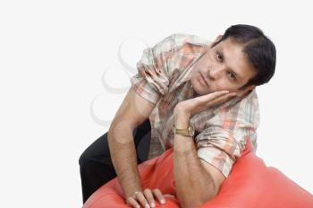 Man leaning on a bean bag and thinking