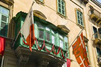 Two flags attached on window of a building, Valletta, Malta