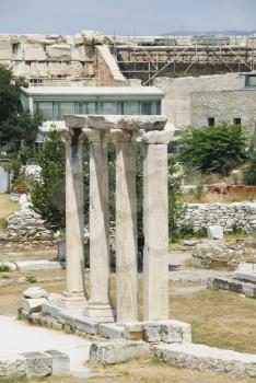 Ruins of a colonnade with buildings in the background, Hadrian's Library, Athens, Greece