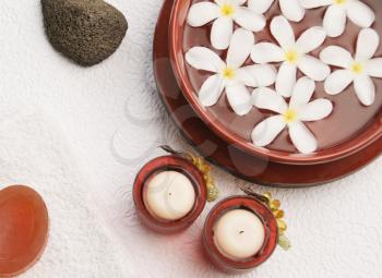 Candles with Frangipani flowers in a bowl
